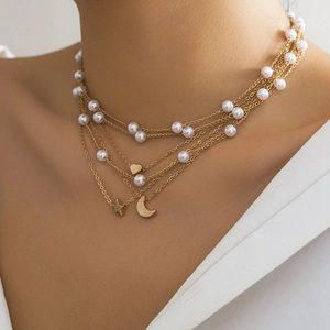 Close-up of layered gold chain necklace featuring faux pearls and star heart pendants