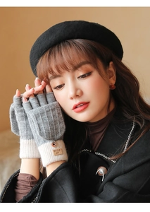 Detail of grey knitted convertible flip top gloves with beige ribbed cuffs and brand tag