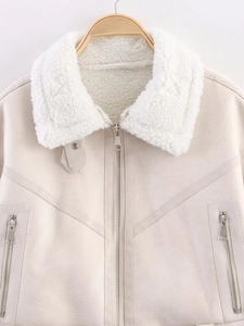 Detail of beige faux suede biker jacket featuring white faux fur collar and metal zippers