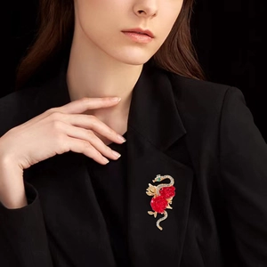 Elegant gold snake brooch with red roses and crystals on a black suit jacket