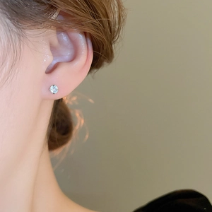 Macro view of sterling silver stud earring with clear zircon in a classic four-prong setting