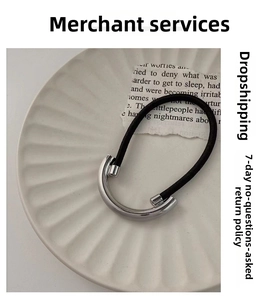 Detail of high-elastic black hair tie with polished silver U-shaped metal tube charm