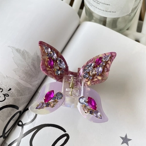 Detail showing gradient purple butterfly hair claw with sparkling rhinestones and resin texture