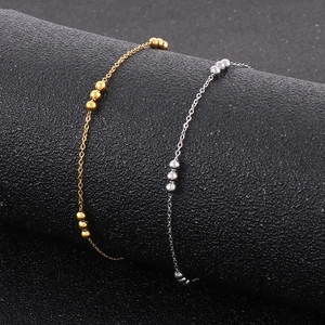 18K gold and silver stainless steel beaded bracelets on a black textured background