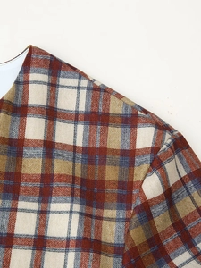 Close-up of red and blue plaid fabric showing woven texture and shoulder seam detail