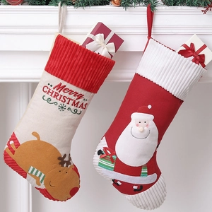 Large Christmas stockings with Reindeer and Santa embroidery hung on a white fireplace