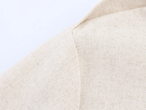 Détail macro de la robe utilitaire kaki montrant la texture du lin et les coutures