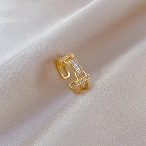 Detail of adjustable gold-plated ring featuring geometric rectangular zircon stones