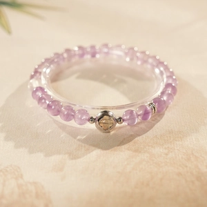 Detailed macro view of purple amethyst beads and silver floral hollow bead on elastic bracelet