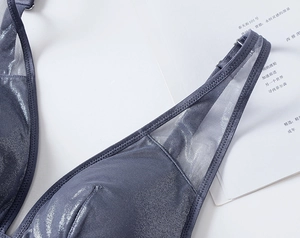 Detail of grey mesh bra showing shiny metallic texture and adjustable thin shoulder straps