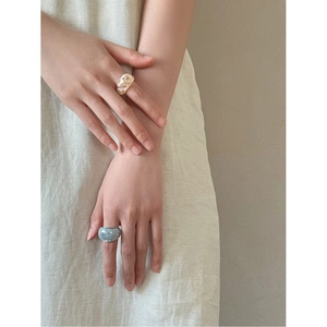 Minimalist oval resin rings in milky white and marble blue on model's hand