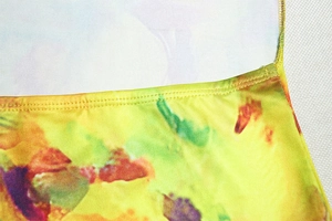 Macro view of double-needle stitching on abstract print knit dress fabric