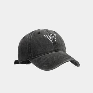 Close-up of washed black denim baseball cap with white Shaka hand gesture embroidery