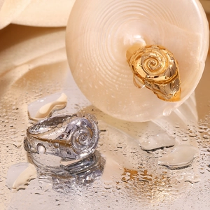 Detailed close-up of 18K gold and silver plated spiral rings with textured relief and water drops