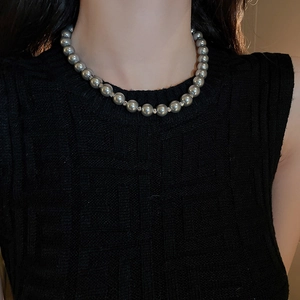 Close-up of grey pearl necklace with silver spacers worn on a female model