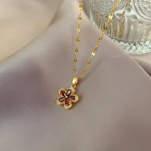 Macro view of pomegranate red five-leaf flower pendant necklace with pavé crystals