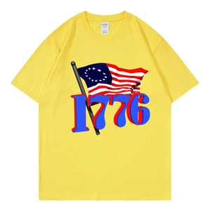 Detail of a yellow cotton T-shirt featuring a classic 1776 graphic and 13-star flag print