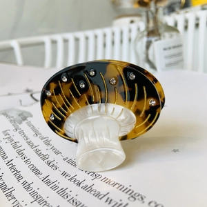 Detailed macro of vintage mushroom hair claw with tortoise pattern and gold accents