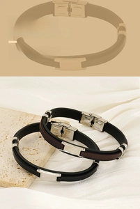 Detail of leather bracelets with stainless steel clasps on a stone and silk background
