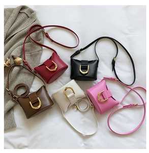 Flat lay of five faux leather saddle bags in red black brown white and pink colors