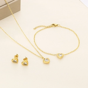 Détail d'une parure cœur en or 18k avec collier, bracelet et boucles d'oreilles clous