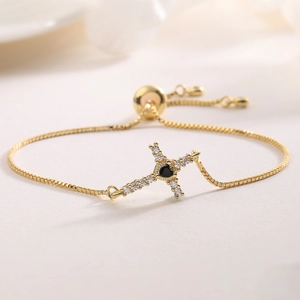 Detail of 18K gold plated cross bracelet with black heart stone and adjustable box chain