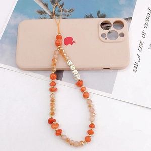 Detail view of handmade phone charm with orange crystals and LOVE letter beads