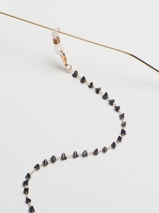 Detail of gold eyewear chain with black triangle beads and silicone anti-slip loops