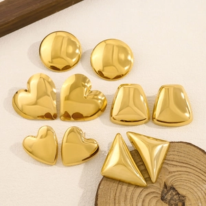 Polished 18K gold heart and geometric stud earring set on minimalist background