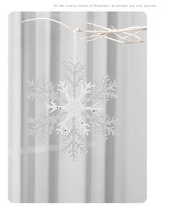 Detail of laser-cut acrylic snowflake ornament with glitter texture hanging on a branch