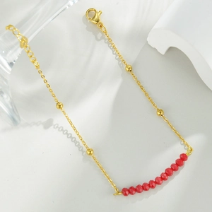 Detail of 14k gold chain bracelet with red faceted beads and adjustable lobster clasp
