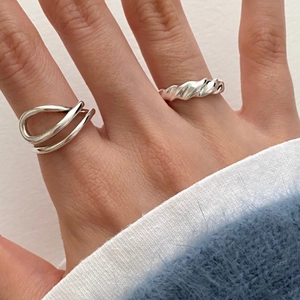 Close-up of minimalist S925 silver rings with twisted and crisscross texture details