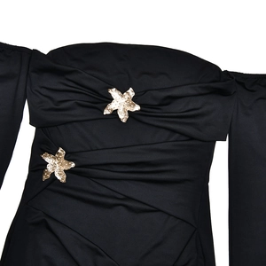 Detailansicht des schwarzen trägerlosen Kleides mit Raffungen und goldenen Stern-Verzierungen