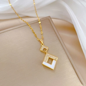 Close-up of golden geometric pendant with white enamel and sparkling zircon pavé detail