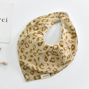 Detailed view of leopard print cotton gauze baby bib with double snap fasteners