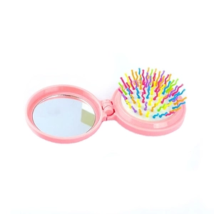 Spazzola pieghevole rosa con specchio e setole arcobaleno su sfondo bianco