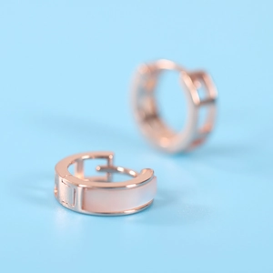 Rose gold geometric silver earrings with inlaid pink shell on a blue background