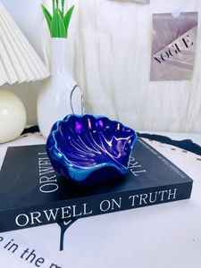 Primo piano di un portasapone in ceramica blu cangiante a forma di conchiglia sul tavolo