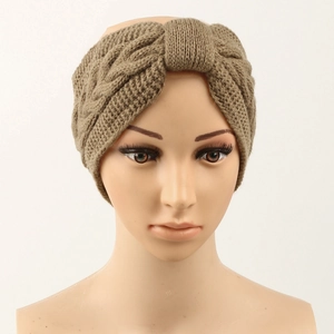 Detail of khaki cable knit headband with a twist knot design on a display head
