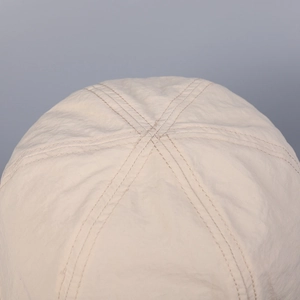 Close-up of the breathable cream sun hat showing high-quality stitching and textured fabric