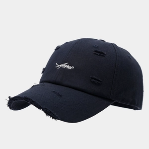Detail shot of vintage distressed baseball cap with white cursive letter embroidery