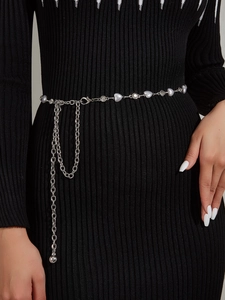 Detail of silver rhinestone waist chain with faux pearls on a black dress