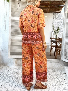 Vue de dos de l'ensemble bohème orange à fleurs avec chemise manches courtes et pantalon large