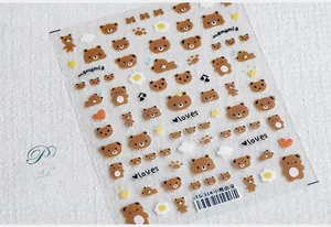 Close-up of 5D self-adhesive nail art stickers featuring cute brown bear patterns