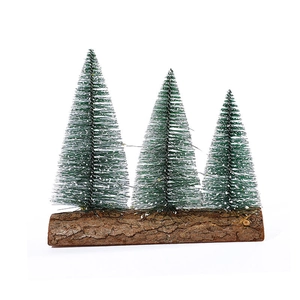 Miniature snow-flocked Christmas trees on natural wood base for festive table decoration