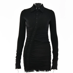 Détail d'une robe chemise noire à manches longues avec boutons et plis drapés