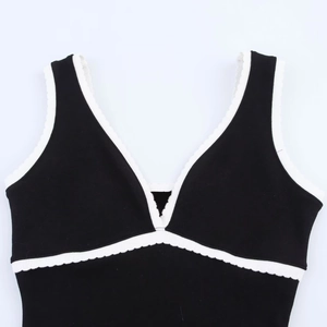Haut caraco chic en tricot noir et blanc avec col en V et bordure décorative ondulée