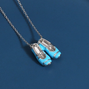 Close-up of blue enamel ballet slipper pendant on a silver-plated link chain