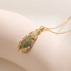 Détail d'un pendentif lapin doré avec des gemmes vertes et blanches sur une chaîne