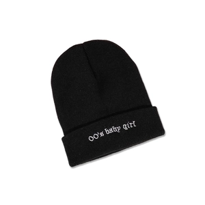 Détail de la broderie blanche '00's baby girl' sur un bonnet en maille côtelée noire